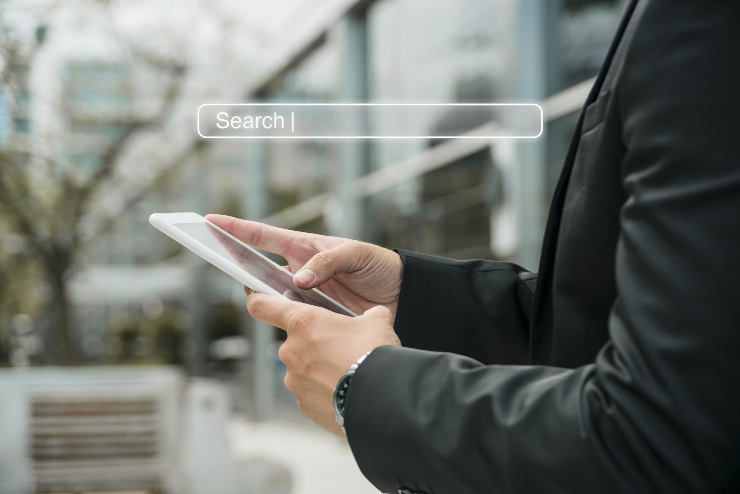 Dłonie mężczyzny trzymające telefon i wyszukujące informacje na Google Maps wskazujące na działanie marketingu lokalnego.