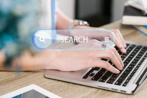 Dłonie piszące na klawiaturze laptopa i opracowujące kampanię płatnych reklam w mediach społecznościowych.