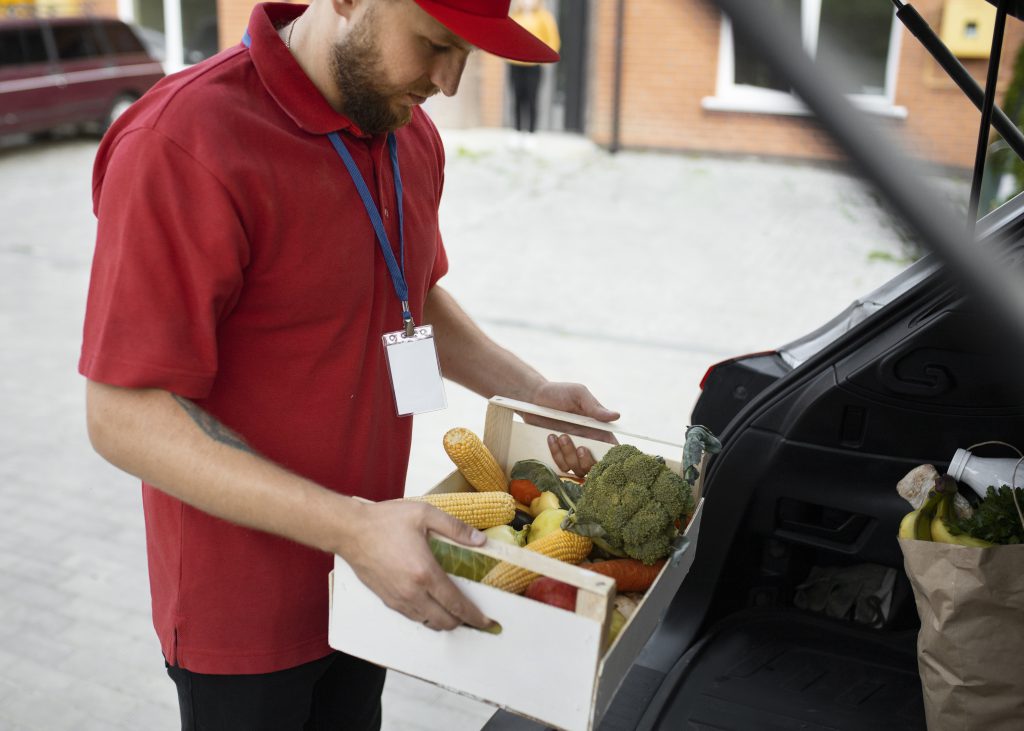 Kurier cateringu z dowozem rozwożący posiłki do klientów.