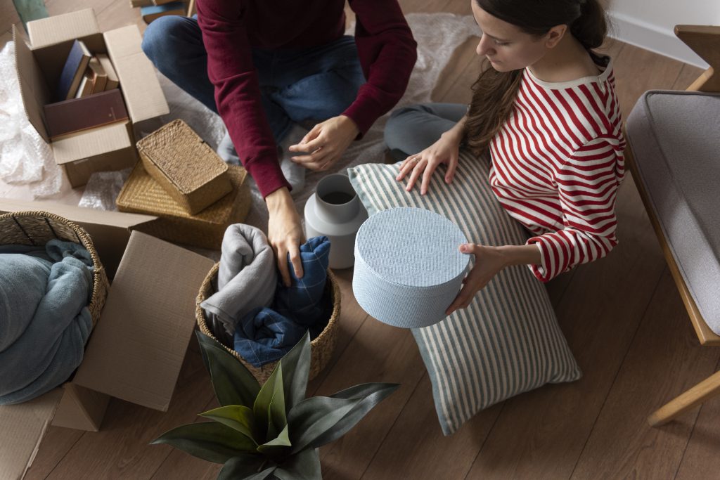 Para pakuje rzeczy do kartonów po sprzedaży mieszkania – skup nieruchomości z lokatorami.