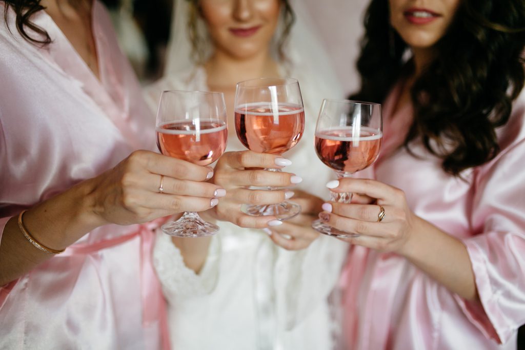 Wieczór panieński Kraków – panna młoda i druhny z różowym winem w dłoniach