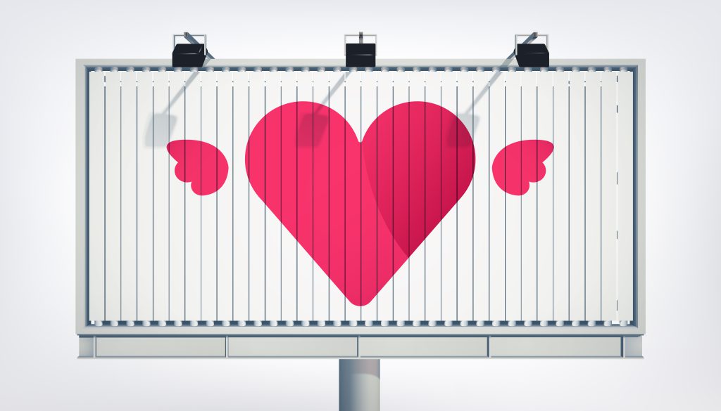 Billboard z dużym różowym sercem, stanowiący przykład ekspozycji wymagającej pozwolenie na reklamę w przestrzeni publicznej.