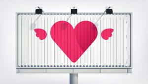 Billboard z dużym różowym sercem, stanowiący przykład ekspozycji wymagającej pozwolenie na reklamę w przestrzeni publicznej.