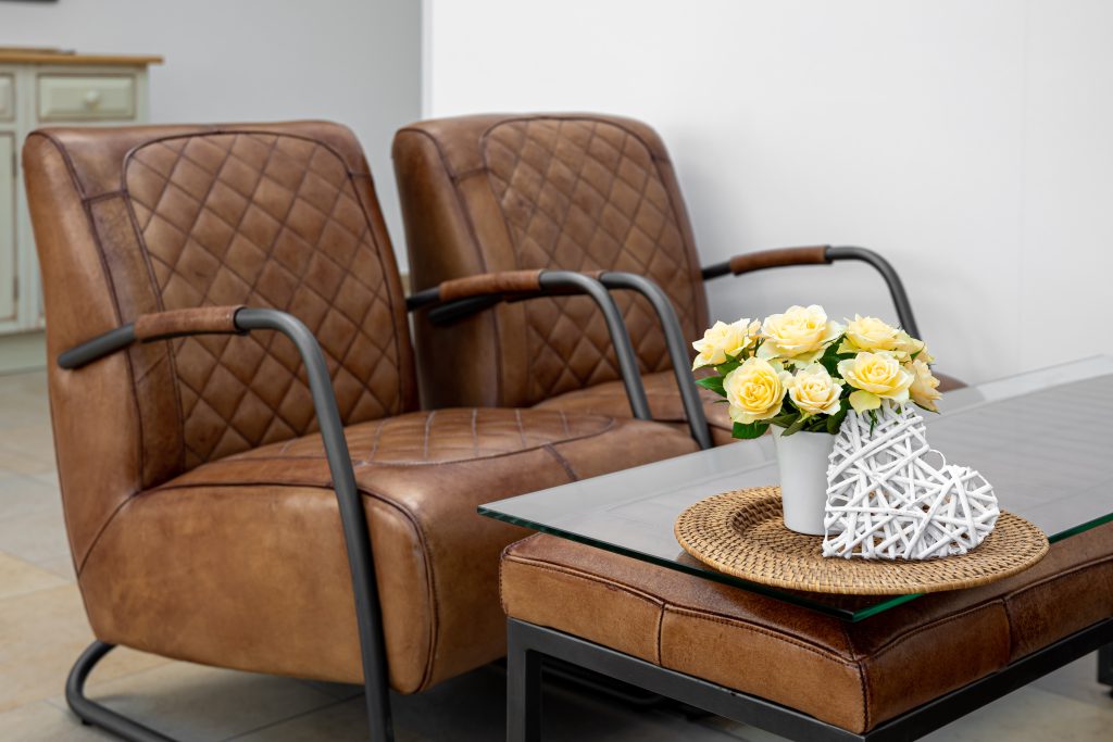 Brązowe meble skórzane w eleganckim salonie z kwiatową dekoracją