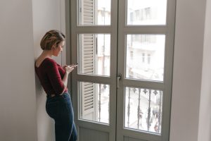 Kobieta stojąca przy nowoczesnym oknie Veka Perfectline w Katowicach – okna Veka Perfectline Katowice do mieszkań