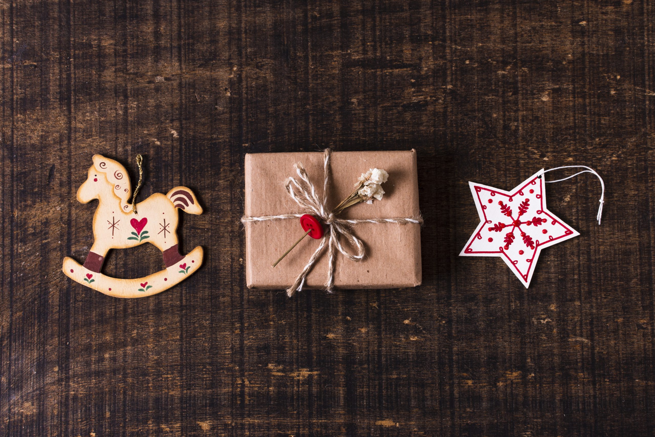 Czekoladki bożonarodzeniowe – ekologicznie zapakowany prezent świąteczny z drewnianymi ozdobami na ciemnym drewnianym tle